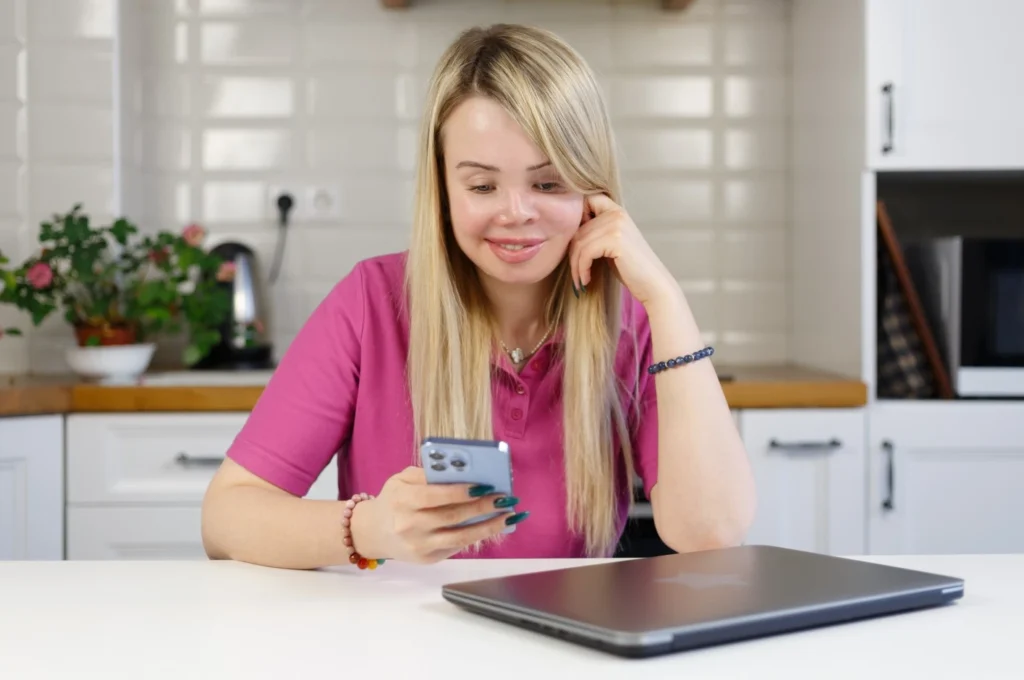 Disabled woman on phone sitting at kitchen bench