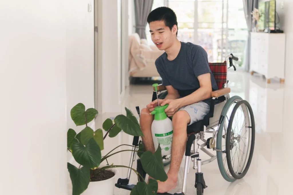 Disabled boy watering plants in home