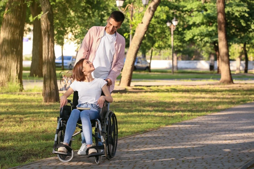 Support worker pushing woman in wheelchair