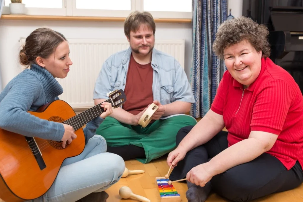 Disabled friends with support worker learning to play musical instruments