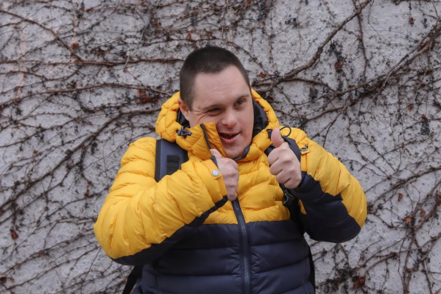 Boy with down syndrome smiling and giving thumbs up